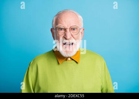 Foto von wütend Rentner alten Mann schreien verrückt Gesicht tragen Specs grünen Pullover isoliert blauen Hintergrund Stockfoto