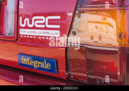 Nahaufnahme der Rückseite eines roten Lancia Delta HF integrale Evoluzione mit Namensschild, Lichtblock und WRC-Logo Stockfoto