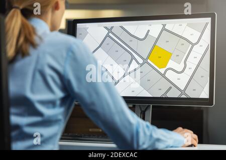 Frau, die mit der digitalen Katasterkarte Land Register-Datenbank arbeitet Computer im Büro Stockfoto