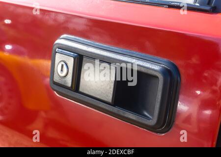 Nahaufnahme des linken Türgriffs an einem Red Lancia Delta HF integrale Evoluzione draußen in der Sonne Stockfoto