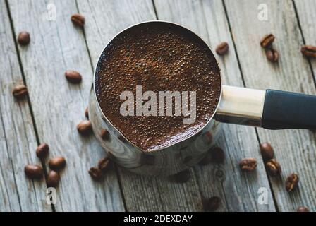 türkischer Kaffee in Cezve auf Holztisch Stockfoto