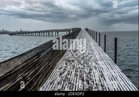 Erster Adventtag, der den Beginn des meteorologischen Winters mit Schnee über dem Holzsteg, Obersee Zürich (Obersee), Schweiz, markiert Stockfoto