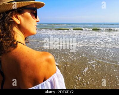 SILVI MARINA, ITALIEN - 19. Sep 2020: Frau von hinten mit Hut schaut aufs Meer und meditiert Stockfoto