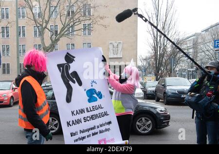 Berlin, Deutschland. Dezember 2020. Linke Aktivisten stehen vor dem Polizeihauptquartier mit einem Plakat in den Händen neben Medienvertretern. Auf dem Luftlift-Gelände hatten Mitglieder einer "Kommunikations-Guerilla-Gruppe" die "Abschaffen der Polizei" zu einer Presseveranstaltung über die Abhebung eingeladen. Adbusting ist eine Form der Aktion, in der Werbung verändert oder imitiert wird, um kritische Botschaften in den öffentlichen Raum zu bringen. Bei der Presseveranstaltung wollten die Aktivisten ein Plakat zum Thema Polizeigewalt an einer Bushaltestelle aufhängen. Dies wurde jedoch von der Polizei verboten. Quelle: Paul Zinken/dpa/Alamy Live News Stockfoto