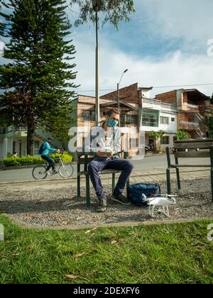 MEDELLIN, KOLUMBIEN - 19. Nov 2020: Medellin, Antioquia / Kolumbien - 18 2020. November: Kaukasischer Mann mit Gesichtsmaske hält die Fernbedienung des Th Stockfoto