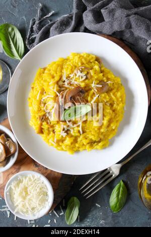 Italienisches Risotto mit Pilzen, Safran und Parmesan auf dunklem Grund. Draufsicht mit Kopierbereich. Stockfoto