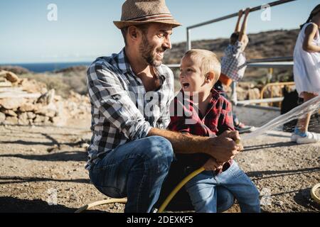 Glücklicher Vater und Sohn Spaß zusammen auf Ranch Farm - Fokus auf Kindergesicht Stockfoto