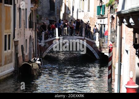 VENEDIG, ITALIEN - 23. Sep 2016: VENEDIG, ITALIEN - 22. SEPTEMBER 2016: Fußgängerbrücke über einen Kanal zwischen alten Häusern, überfüllt mit Touristen Stockfoto