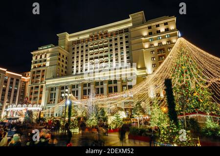 Moskau, Russland - 20. Dezember 2019: Weihnachtsmarkt auf dem Manezhnaya-Platz mit dem Hotel Moskva im Hintergrund, Moskau, Russland Stockfoto