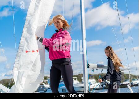 Zwei Mädchen beschlossen, ein Wochenende auf dem Fluss zu verbringen, die Vorbereitung der Yacht auf das Wasser zu gehen. Stockfoto