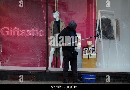 Nottingham, Nottinghamshire, Großbritannien. Dezember 2020. Ein Reiniger wäscht die Fenster von Debenhams, nachdem die Kaufhauskette zusammenbrach, aber ihre Geschäfte für einen Lagerverkauf öffnete. Credit Darren Staples/Alamy Live News. Stockfoto