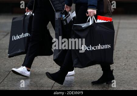 Nottingham, Nottinghamshire, Großbritannien. Dezember 2020. Frauen tragen Debenhams Taschen, nachdem die Kaufhauskette zusammengebrochen ist, aber ihre Geschäfte für einen Lagerverkauf geöffnet hat. Credit Darren Staples/Alamy Live News. Stockfoto