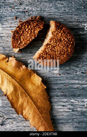 Blick auf ein Mantecado, eine typische weihnachtskonfektion in spanien, gekrönt mit Sesam auf einem rustikalen grauen Holztisch Stockfoto