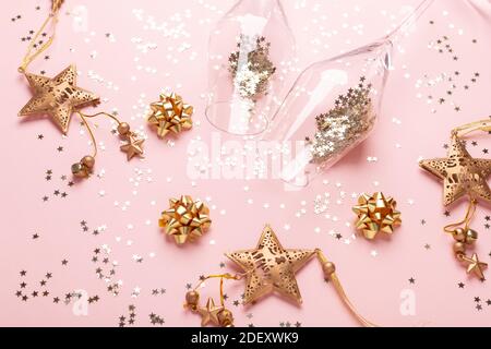 Weihnachten flach legen. Champagnergläser und Golddekoration auf rosa Hintergrund - Bild Stockfoto