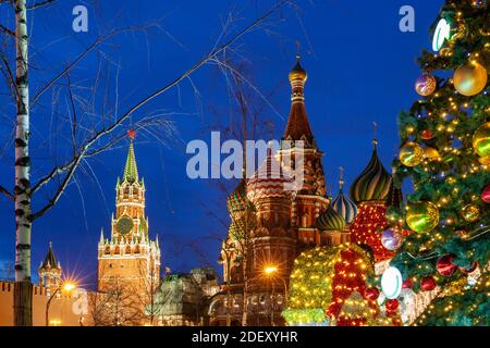 Weihnachtsbaum auf dem Roten Platz mit der Basilius-Kathedrale und dem Spasskaya-Turm im Hintergrund, Moskau, Russland Stockfoto