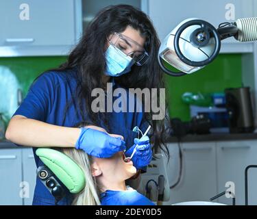Eine Nahaufnahme einer Zahnärztin, die an ihrer Patientin arbeitet Zähne Stockfoto