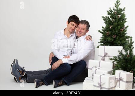 Weihnachten thematisierte horizontale Business-Paar Porträt gekleidet smart casual in blau, weiß, beige Hosen und Blazer auf grauem Hintergrund. Stockfoto