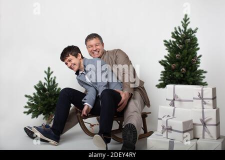 Weihnachten thematisierte horizontale Business-Paar Porträt gekleidet smart casual in blau, weiß, beige Hosen und Blazer auf grauem Hintergrund. In der Vorgruppe Stockfoto