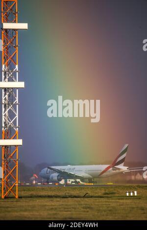 Glasgow, Schottland, Großbritannien. Dezember 2020. Im Bild: Ein intensiver Regenbogen füllt den Himmel an einem kalten, nassen und windigen Tag über dem Flughafen Glasgow im Zentrum Schottlands. Die Temperaturen werden an diesem Abend auf knapp über dem Gefrierpunkt sinken. Gedreht am Flughafen Glasgow mit dem Emirates Boeing 777-300ER Flug, der nach Dubai abfliegt. Quelle: Colin Fisher/Alamy Live News Stockfoto