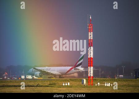 Glasgow, Schottland, Großbritannien. Dezember 2020. Im Bild: Ein intensiver Regenbogen füllt den Himmel an einem kalten, nassen und windigen Tag über dem Flughafen Glasgow im Zentrum Schottlands. Die Temperaturen werden an diesem Abend auf knapp über dem Gefrierpunkt sinken. Gedreht am Flughafen Glasgow mit dem Emirates Boeing 777-300ER Flug, der nach Dubai abfliegt. Quelle: Colin Fisher/Alamy Live News Stockfoto