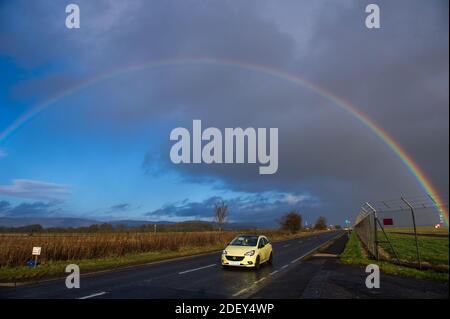 Glasgow, Schottland, Großbritannien. Dezember 2020. Im Bild: Ein intensiver Regenbogen füllt den Himmel an einem kalten, nassen und windigen Tag in Zentralschottland. Die Temperaturen werden an diesem Abend auf knapp über dem Gefrierpunkt sinken. Aufgenommen am Flughafen Glasgow. Quelle: Colin Fisher/Alamy Live News Stockfoto