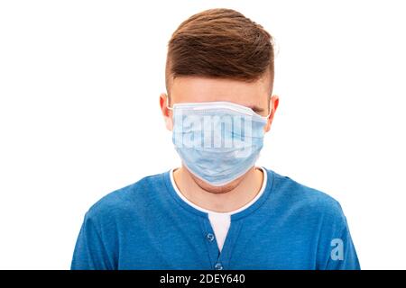 Der junge Mann versteckt sein Gesicht mit einer isolierten Grippemaske Auf dem weißen Hintergrund Stockfoto