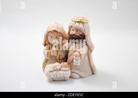 Darstellung einer Weihnachtskrippe mit den Figuren des Jesuskindes, Maria und Josef auf einem weissen Weihnachtskonzept. Stockfoto