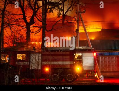 Brand im Fabrikgebäude bei Nacht. Brandgefahr durch Feuer im Industrielager. Stockfoto