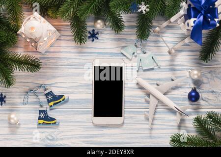 Reiseplanung zu Weihnachten oder Neujahr. Mockup leerer Bildschirm Smartphone mit Flugzeug-Modell für Urlaubsreisen. Flache Lay-Ansicht von oben. Speicherplatz kopieren Stockfoto