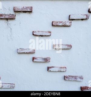 Weiße Steinmauer mit orangefarbenen Ziegeln, Texturhintergrund Stockfoto