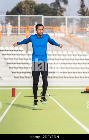 Stock Foto von afroamerikanischen männlichen Athleten Stretching in athletische Strecke. Stockfoto