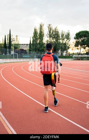 Stock Foto von nicht erkannten behinderten Athleten gehen mit seinem Rucksack in der Laufstrecke. Stockfoto