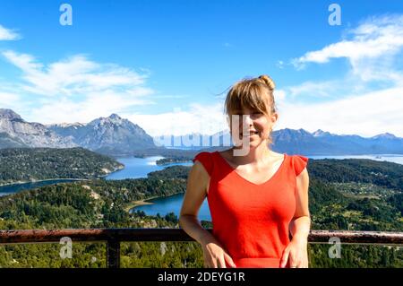 Frau von vorne mit Bergen im Hintergrund, Pinien und See. Stockfoto