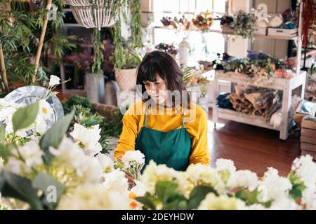 Stock Foto von Frau, die in Floristen-Shop kümmert sich um weiße Blumen. Stockfoto