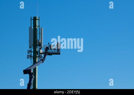 Telekommunikationsturm mit 4G-, 5G-Sendern, Arbeiter auf Mobilfunkbasisstation Stockfoto