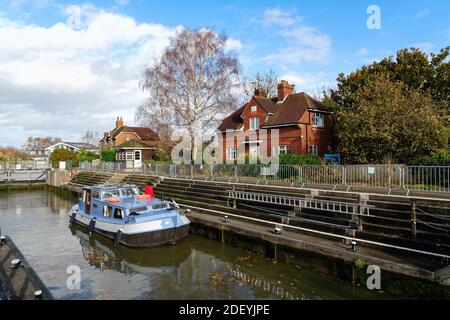 Ein kleines privates Flussboot, das an einem Herbsttag durch die Schleuse in Old Windsor fährt, Berkshire England Stockfoto