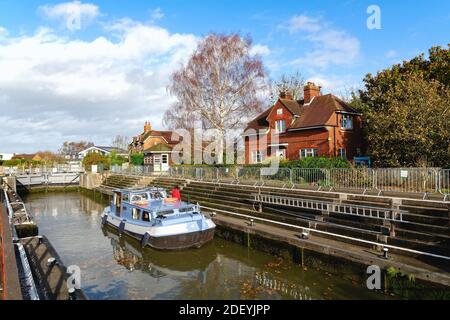 Ein kleines privates Flussboot, das an einem Herbsttag durch die Schleuse in Old Windsor fährt, Berkshire England Stockfoto