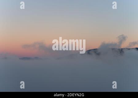 Vancouver City Mountains über dem Nebel mit der Morgensonne, die einen reflektierenden falschen Sonnenuntergang erzeugen, wie eine bildgebende Olympus god Mount Stockfoto