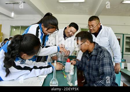 (201202) -- LHASA, 2. Dezember 2020 (Xinhua) -- Cai Chunting (C), ein Lehrer aus der Stadt Xiangyang in der zentralchinesischen Provinz Hubei, und Cering Choden (Rückseite R), ein lokaler Lehrer, Tutor Schüler in einem chemischen Experiment in Shannan No.1 Senior High School, südwestlich Chinas Tibet Autonome Region, 7. Mai 2019. Die chinesische Regierung hat bisher mehr als 20 Milliarden Yuan für die Unterstützung des freien Bildungsprogramms der Region ausgegeben, wodurch Bildung für fast neun Millionen Studenten zugänglicher wurde. Studierende aller Klassen können zudem über eine Reihe von Projekten und Initiativen auf zusätzliche Unterstützung zugreifen Stockfoto