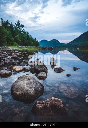 Acadia's Bubbles spiegelte sich in einem ruhigen Jordan Pond auf einem Sommerabend Stockfoto