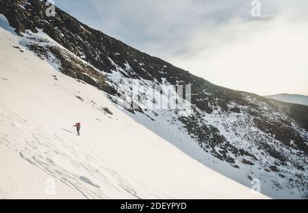 Skifahrer bestiegen Huntington Ravine bei Sonnenaufgang in den White Mountains Stockfoto