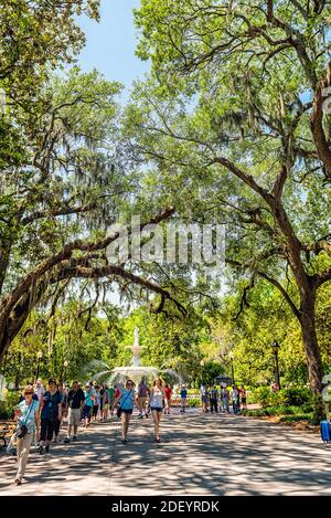 Savannah, USA - 11. Mai 2018: Berühmte Wasserfontäne vertikale Ansicht in Forsyth Park, Georgia während sonnigen Tages im Sommer mit Menschen zu Fuß auf Gasse str Stockfoto