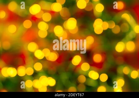 Bokeh gelb LED Beleuchtung auf einem verschwommenen rot-grünen Hintergrund. Defokussierung Lichter einer elektrischen Girlande. Dekoration und Design-Element für den Urlaub. Stockfoto