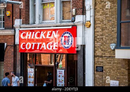 London, Großbritannien - 22. Juni 2018: Chicken Cottage Restaurant Fast-Food-Shop mit Menschen durch Eingang außen auf Tooley Straße mit rotem Logo Stockfoto