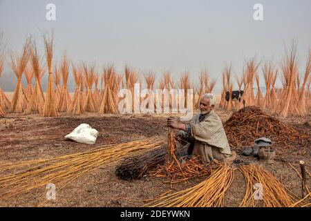 Srinagar, Indien. Dezember 2020. Ein Kashmiri Mann bereitet Zweige, um 'Kangris', (traditionelle Feuertöpfe) in Shlabugh Dorf des Bezirkes Ganderbal ungefähr 22kms von Srinagar zu bilden, Die Sommerhauptstadt von Jammu und Kaschmir.die Kangri ist ein traditioneller Feuertopf, der die Menschen während der schweren Wintermonate warm hält, wenn die Temperatur bis zu minus 20 abtaucht. Kangri ist aus Ton und Zweigen, in denen heiße Kohle gehalten wird. Kredit: SOPA Images Limited/Alamy Live Nachrichten Stockfoto