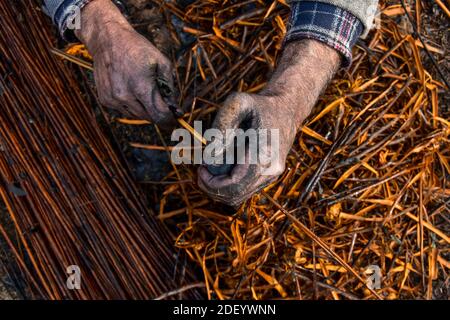 Srinagar, Indien. Dezember 2020. Ein Kashmiri Mann bereitet Zweige, um 'Kangris', (traditionelle Feuertöpfe) in Shlabugh Dorf des Bezirkes Ganderbal ungefähr 22kms von Srinagar zu bilden, Die Sommerhauptstadt von Jammu und Kaschmir.die Kangri ist ein traditioneller Feuertopf, der die Menschen während der schweren Wintermonate warm hält, wenn die Temperatur bis zu minus 20 abtaucht. Kangri ist aus Ton und Zweigen, in denen heiße Kohle gehalten wird. Kredit: SOPA Images Limited/Alamy Live Nachrichten Stockfoto