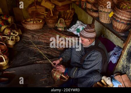 Srinagar, Indien. Dezember 2020. Ein Kashmiri-Mann macht einen 'Kangri', einen traditionellen Feuertopf in seiner Werkstatt am Stadtrand von Srinagar, der Sommerhauptstadt von Jammu und Kaschmir.der Kangri ist ein traditioneller Feuertopf, der die Menschen während der schweren Wintermonate warm hält, wenn die Temperatur bis zu minus 20 abnimmt. Kangri ist aus Ton und Zweigen, in denen heiße Kohle gehalten wird. Kredit: SOPA Images Limited/Alamy Live Nachrichten Stockfoto