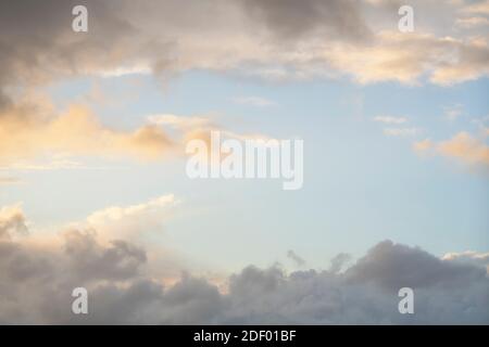 Wolken am Himmel als Rahmen, Sonnenuntergang Textur Hintergrund. Abstrakte Blautöne, Orange und Gelb. Echte hochauflösende Fotografie Stockfoto