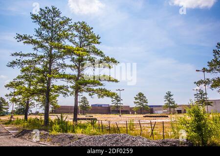 Augusta, GA USA - 07 04 20: Verlassene Regency Shopping Mall Eckgebäude Blick aus der Ferne und Zaun Stockfoto