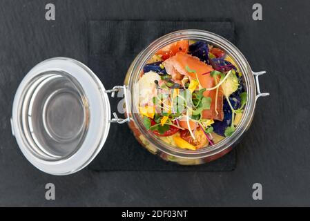 Blick von oben auf authentisches italienisches Essen zeigt nahrhaften Salat in einem lauwarmen Glas gefüllt mit Zutaten und bereit zu essen. Stockfoto